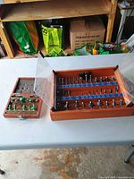 Two wooden cases of router bits on table