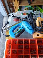 Overall view showing blue electric stapler, wire brush, yellow stapler and organizer