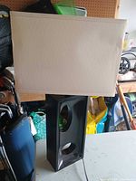 Full view of lamp showing black base with circular openings and rectangular cream shade