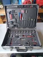 Tool case open showing sockets, screwdrivers, ratchet and accessories