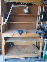 Overall view of workbench, pegboard, shelves, lamp, vice, Dremel stand, power bar
