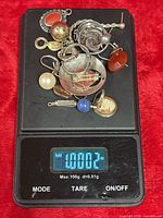Mixed sterling scrap jewelry on scale, weight 1.0002 oz displayed