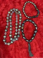 Necklace and both bracelets laid on red fabric