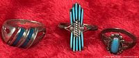 All three sterling silver turquoise rings on red background
