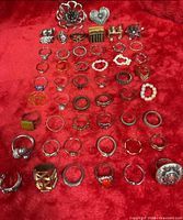 Top-down view of all 50 rings arranged on red fabric