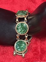 bracelet on display showing three jade links and gold-filled detailing