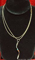 Necklace draped on display bust showing full chain length and pendant