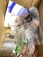 Box containing mixed bags of jump rings in various metal finishes