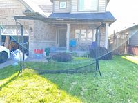 Full view of assembled black golf net on lawn