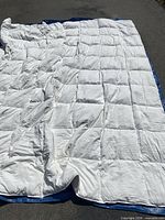 Full view of white quilted duvet laid out flat