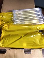 Four yellow-wrapped toner cartridges in box