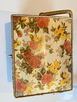 Closed sewing box exterior showing floral fabric and braided trim