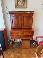 Front view of mahogany bar cabinet with doors closed and drawers visible