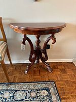 Front view of demilune console table showing carved legs and overall shape