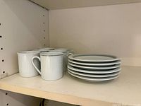 Stacked demitasse cups and saucers on shelf