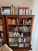 Full bookcase showing three shelves filled with assorted books
