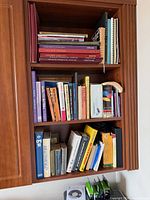 Two lower shelves filled with vertically arranged mixed subjects and formats