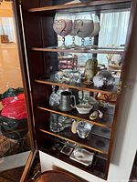 Cabinet shelves showing goblets and assorted collectibles