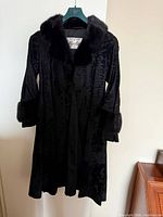 Front view of black Revlis fur coat with collar and cuffs visible