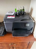 Front and top view of HP OfficeJet Pro 8710 printer with ink packages and installation CD