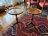 Both wooden scalloped side tables on rug showing full forms