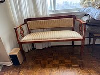 Overall front view of wooden bench showing upholstery and frame