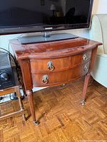 Front angled view of the bow front console table under television