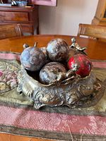 overhead view of ornate metal centerpiece filled with five decorative balls
