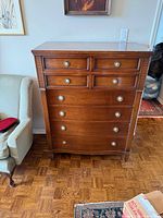 Front view of wooden 8-drawer dresser showing overall form and hardware