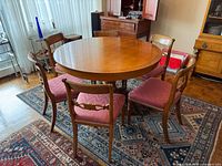 full view of round table with six chairs on rug