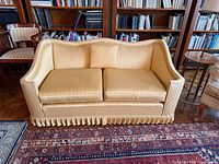 Front view showing sofa, cushions, pleated skirt, and overall upholstery condition