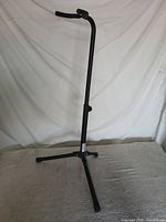 Full view of black adjustable tripod guitar stand