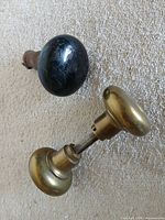 Brass knob set and black mineral knob side by side