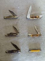 All six folding knives arranged side by side, various handles and blades