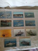 Overview of 11 naval and military postcards laid out on cloth
