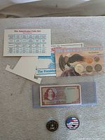 Overview of all items: coin card, specification card, stand, banknote in sleeve, two challenge coins