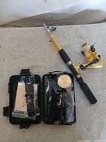 Overall lot: telescopic rod, reel, open survival case with contents