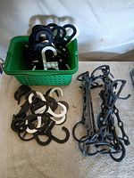 Overall lot: basket filled with S-hook hangers, additional hangers and cascade bars on table