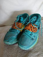 Front view of both shoes showing toe box, laces, mismatched animal-print straps