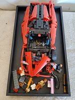 Top view of assembled red sports car and loose pieces in tray