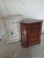 Both jewelry cabinets side by side showing size and style contrast