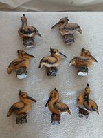 All eight pelican figurines displayed on cloth