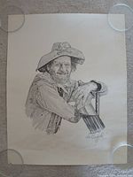 Full view of charcoal sketch on paper with glass weights at corners