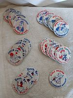 All six stacks of duplicate pinback buttons laid out on fabric
