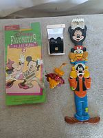 Group view of all four Disney items: cassette set, Minnie charm in box, Simba figure, character totem figurine