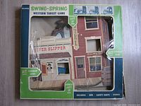 Front of boxed Eldon Swing-Spring Western Target Game showing Western street target façade and damaged plastic window