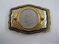 Front view of belt buckle showing coin and decorative border