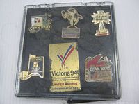 Front view of case showing six enamel pins inside deteriorated foam backing