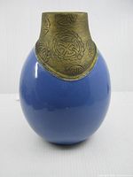 Front view showing blue body and decorative brass-tone collar