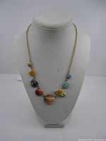 Full view of necklace on bust showing planet beads and chain